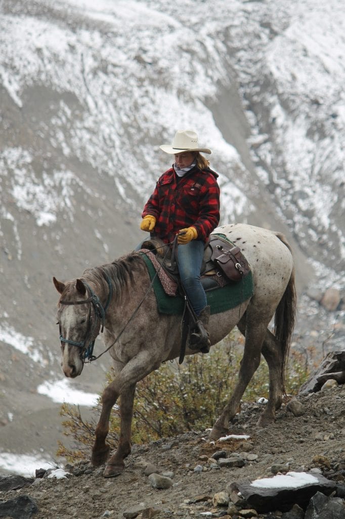 Cowgirl riding in Canada mountains
